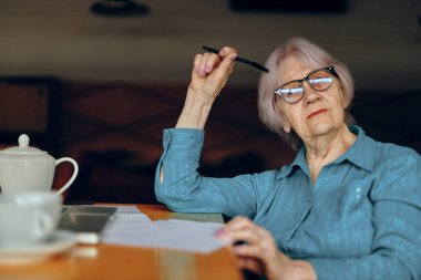 Bir iş kadını kağıt ve kalem kağıtlarını belgeledi Freelancer değiştirilmeden çalıştı