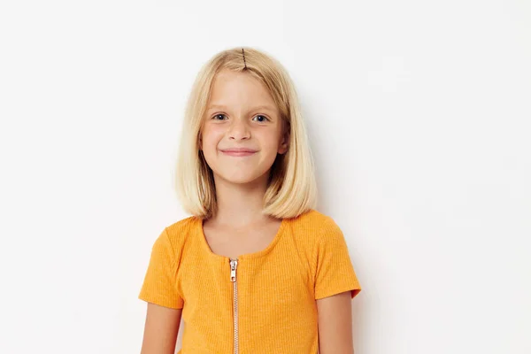 Fröhliches Mädchen in einem gelben T-Shirt posiert Emotionen hellen Hintergrund — Stockfoto