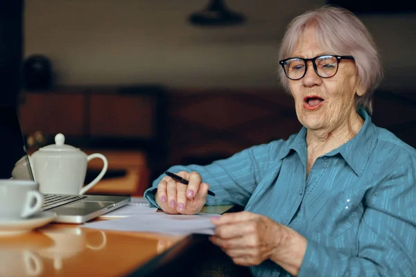 Hermosa madura mujer mayor en un café una taza de bebida portátil Mujer jubilada charlando inalterada — Foto de Stock
