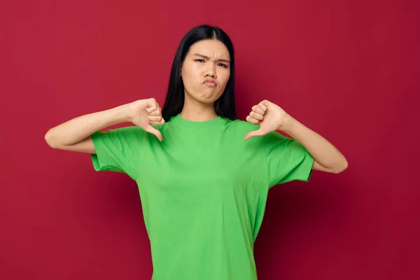 年轻的亚洲女子迷人的绿色T恤手势，双手红底不变 — 图库照片