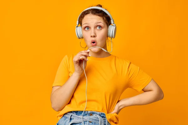 Lustiges Mädchen mit Kopfhörer-Jeans-Shorts Nahaufnahme Emotionen gelber Hintergrund unverändert — Stockfoto