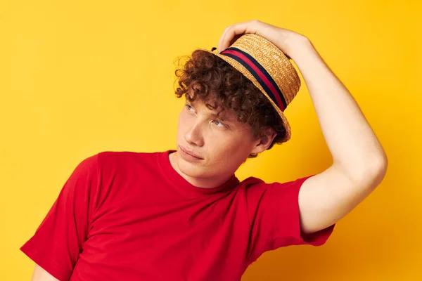 Joven rizado hombre emociones rojo camiseta sombrero estudio amarillo fondo inalterado — Foto de Stock