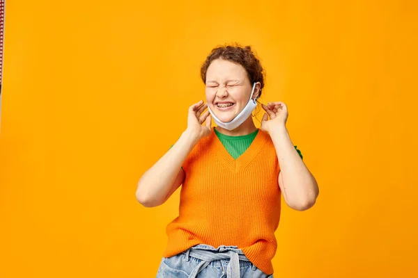 Cheerful woman in a yellow t-shirt medical mask protection pink background unaltered — 图库照片