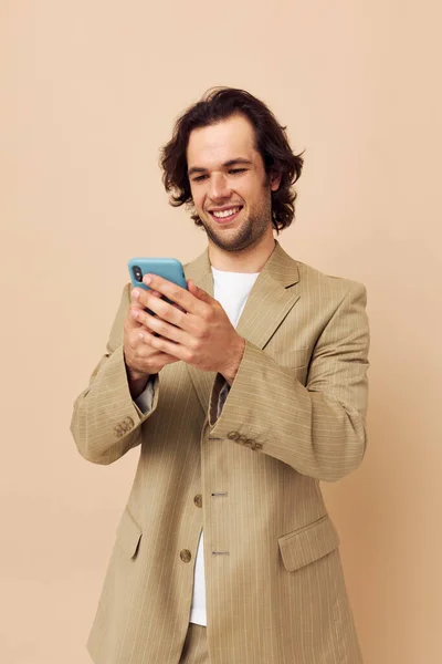 Красивий чоловік у костюмі позує емоції, дивлячись на телефон Стиль життя незмінний — стокове фото