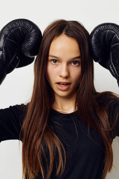 若い女性でボクシンググローブパンチで黒パンツとTシャツ隔離された背景 — ストック写真