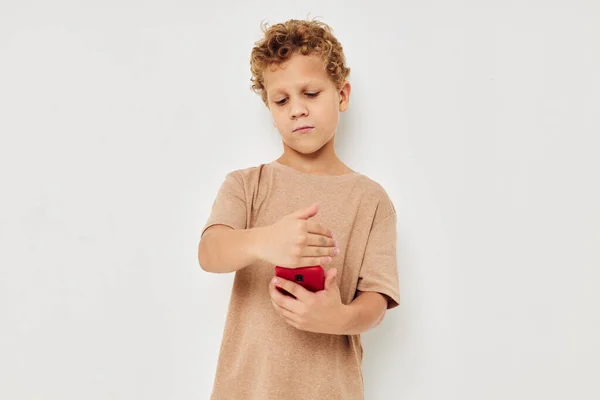 Garçon beige t-shirts avec téléphone posant la technologie — Photo