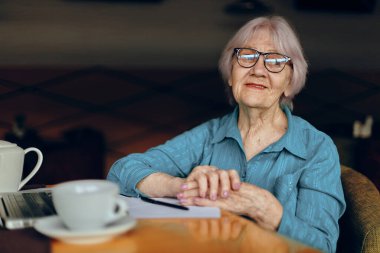 Yaşlı kadın kağıt ve kalemle ilgili çalışma kağıdını ve yaşam tarzını değiştirmeden belgeledi