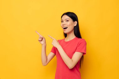 Kırmızı tişörtlü bir kadın. Duygularını belli ediyor. Eğlenceli bir arka plan.