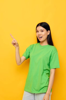 Yeşil tişörtlü kadın duyguları ile poz veriyor. Kopyalama alanı izole edilmiş arka plan değiştirilmemiş.