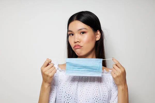 Charmig ung asiatisk kvinna medicinsk mask på huvudet skydd studio modell oförändrad — Stockfoto