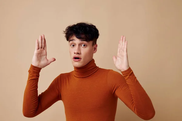 Egy fiatal férfi pózol barna pulóver önbizalom divat fény háttér változatlan — Stock Fotó