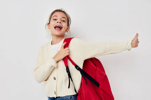 Милая девушка жестом руки красный рюкзак легкий фон — стоковое фото