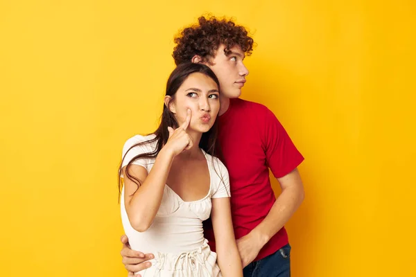 Tieners knuffelen samen capriolen gele achtergrond ongewijzigd — Stockfoto
