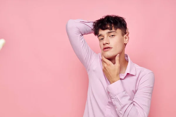 Un hombre joven gestos con las manos emociones peinado moda rosa fondo inalterado —  Fotos de Stock