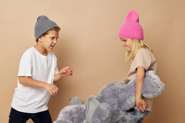 Leuke stijlvolle kinderen in hoeden met een teddybeer vriendschap Lifestyle onveranderd — Stockfoto
