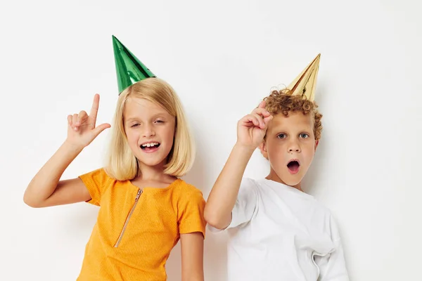 Portrait of cute children with caps on his head holiday entertainment light background — Zdjęcie stockowe