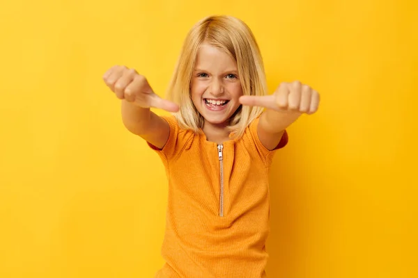 Young blonde girl in a yellow t-shirt smile posing studio childhood lifestyle unaltered — Stock fotografie