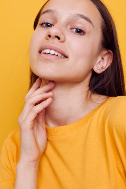 Sarı tişörtlü güzel bir kız yaz tarzı sarı arka planda.