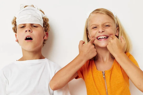 Portret van schattige kinderen in medische masker bescherming poseren grimas licht achtergrond — Stockfoto