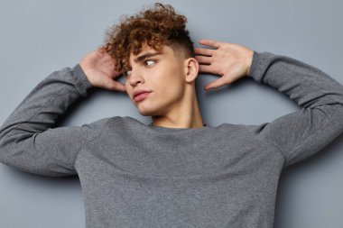 Gri kazaklı çekici bir adam. Moda stüdyosu izole edilmiş.