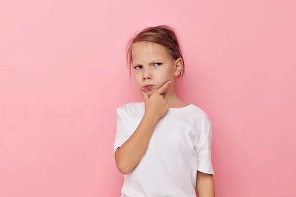 Little girl in a white t-shirt smile pink background — Stockfoto