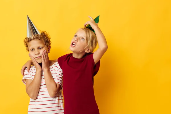 Retrato de niños lindos en ropa casual con gorras en la cabeza sobre fondo de color —  Fotos de Stock