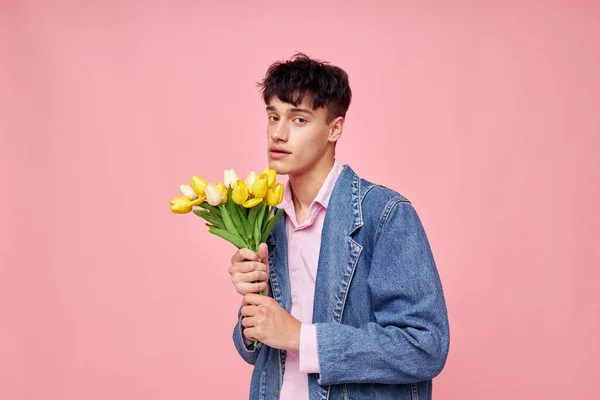 Портрет молодого чоловіка букет жовтих квітів подарунок свято елегантний стиль рожевий фон незмінний — стокове фото