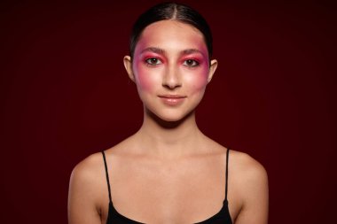 Seksi esmer kadın gülümseme makyaj çekici pembe arka plan değişmemiş