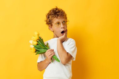 Bir buket sarı çiçekli sevimli çocuk. Arka planı değiştirilmemiş.