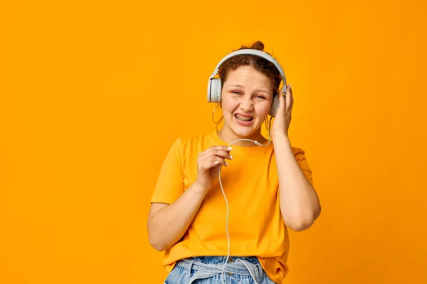 Güzel kız kulaklıkla müzik dinliyor. Gençlik tarzı, izole edilmiş arka planlar, değiştirilmemiş. — Stok fotoğraf