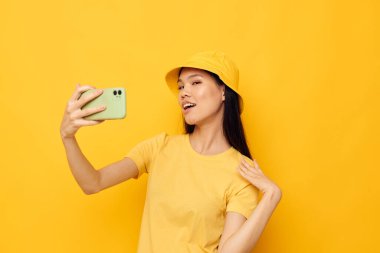 Çekici genç Asyalı kadın telefonda konuşuyor. Moda pozu veriyor. Geçmişi değişmemiş.