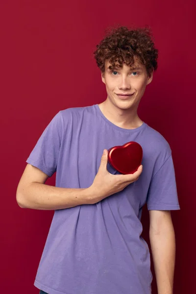 Söt kille i lila t-shirt hjärtformade gåva semester — Stockfoto
