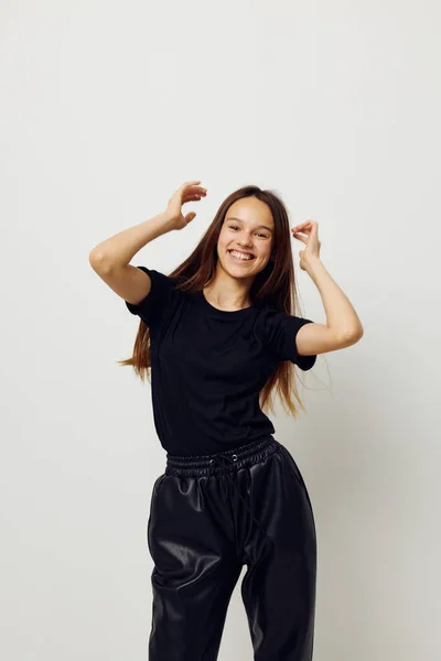 Foto vacker flicka i svarta byxor och en T-shirt mode ljus bakgrund — Stockfoto