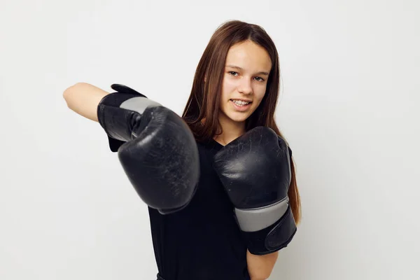 Joven hermosa mujer en negro deportes uniforme boxeo guantes posando aislado fondo — Foto de Stock