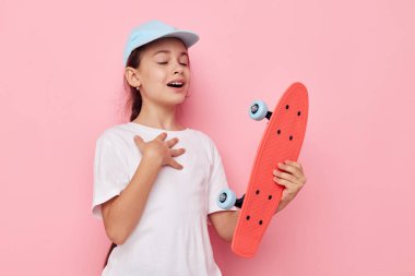 Çocukluğunda elinde kaykayla gezen sevimli bir kız.