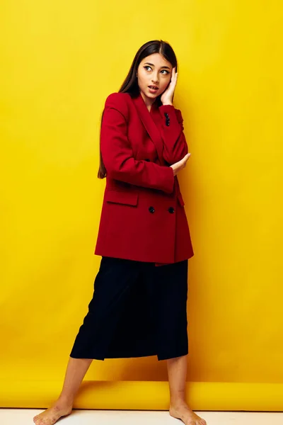 Menina atraente em uma jaqueta vermelha cosméticos sorriso amarelo fundo inalterado — Fotografia de Stock