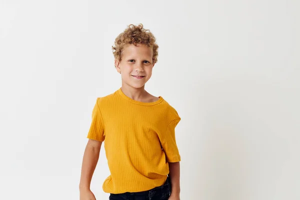 Sarı tişörtlü kıvırcık saçlı çocuk. — Stok fotoğraf