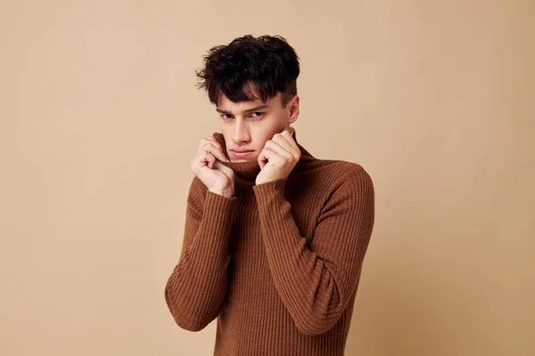 Портрет молодого чоловіка, що позує в коричневому светрі впевненість у собі мода ізольований фон незмінний — стокове фото