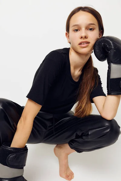 Jonge mooie vrouw in bokshandschoenen op de vloer in zwart t-shirt fitness training — Stockfoto