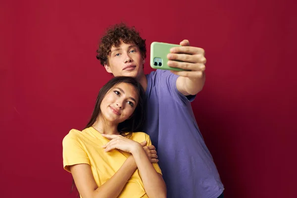 Una giovane coppia stile moderno emozioni divertimento telefono rosso sfondo — Foto Stock