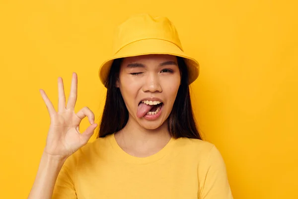 迷人的年轻亚洲女人戴着一顶黄色的帽子，看起来很有情调 — 图库照片