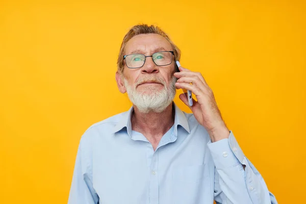 Viejo hombre barba gris con gafas hablando en el teléfono aislado fondo —  Fotos de Stock