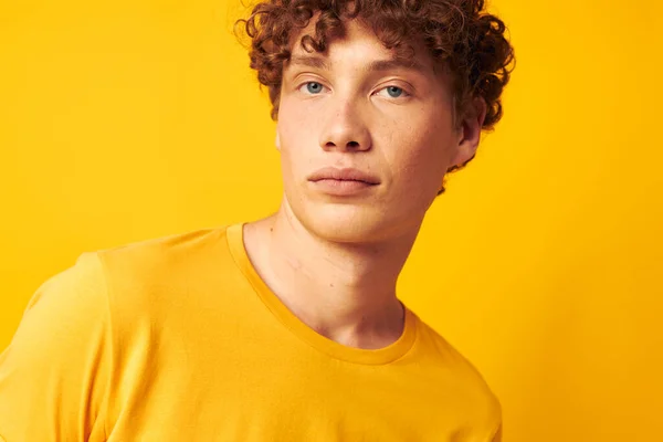 Tipo con pelo rizado rojo gafas de estilo juvenil estudio casual desgaste amarillo fondo inalterado — Foto de Stock