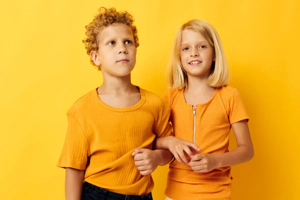 노란 티셔츠를 입고 나란히 서 있는 귀여운 아이들은 어린 시절의 감정들을 격리 된 배경 속에서 간직하고 있습니다 — 스톡 사진