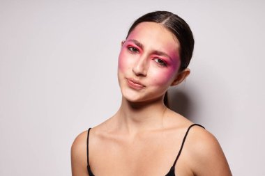 Seksi esmer kadın. Pembe yüz makyajı. Çekici görünüyor.