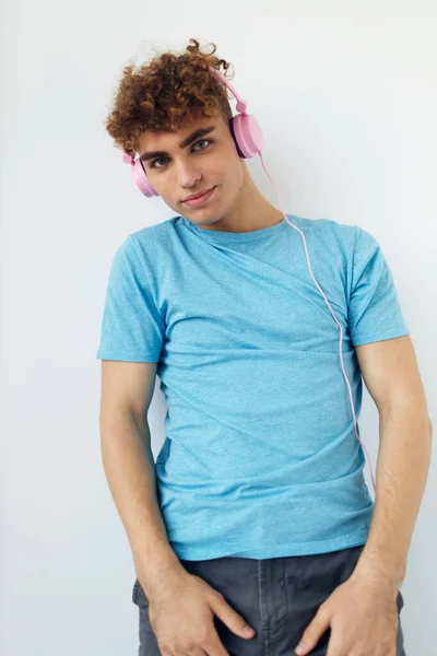 穿着蓝色T恤衫的英俊年轻人，粉色耳机，时尚，隔离的背景 — 图库照片