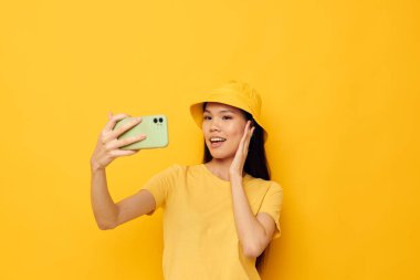 Çekici genç Asyalı kadın telefonda konuşuyor. Moda pozu veriyor. Geçmişi değişmemiş.