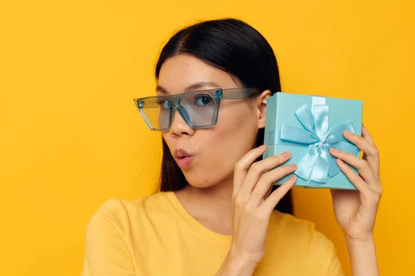 Asyalı görünüşlü kadın sarı tişörtlü doğum günü hediyesi kutusu değiştirilmemiş arka plan. — Stok fotoğraf