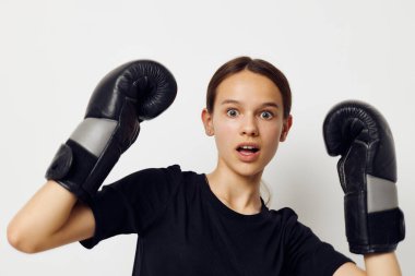 Siyah pantolonlu, boks eldivenli ve spor tişörtlü güzel bir kız.