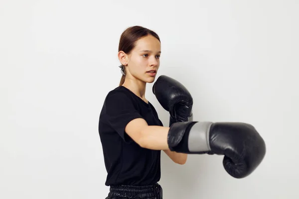 Foto bonita chica en guantes de boxeo en pantalones negros y un entrenamiento de fitness camiseta —  Fotos de Stock